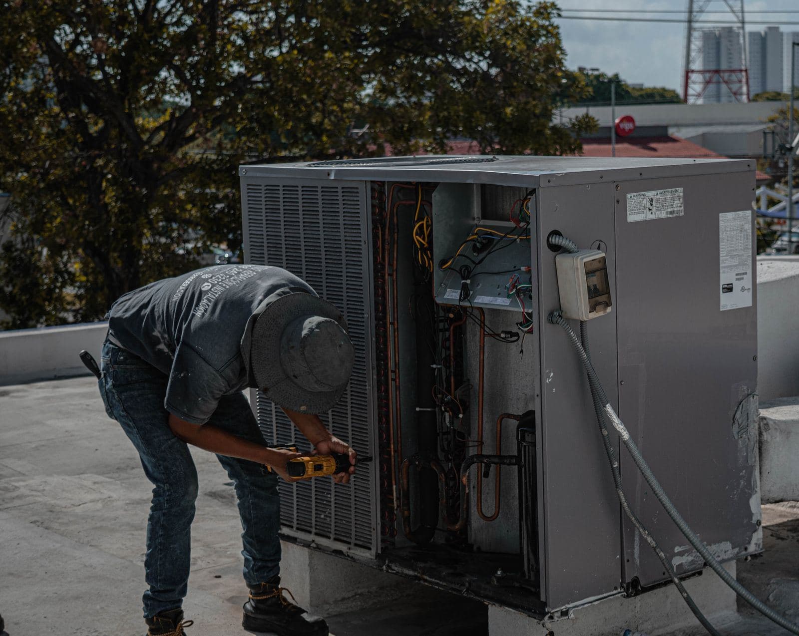 Technician testing an outdoor air conditioning unit with a meter